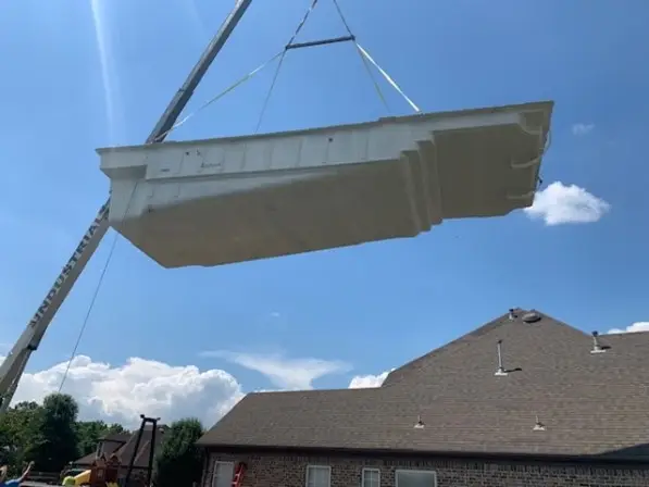Craning a pool over the house for a fiberglass pool installation